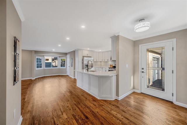 kitchen featuring white cabinetry, sink, stainless steel appliances, and wood-type flooring