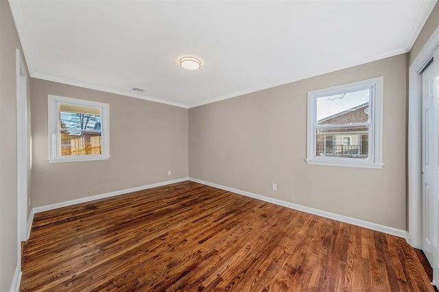 empty room featuring dark hardwood / wood-style floors and ornamental molding