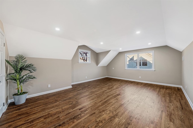 bonus room with dark hardwood / wood-style flooring and vaulted ceiling