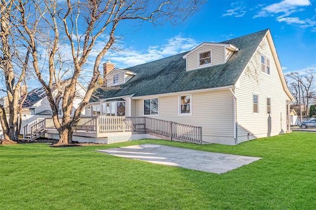 rear view of property with a deck, a patio area, and a lawn