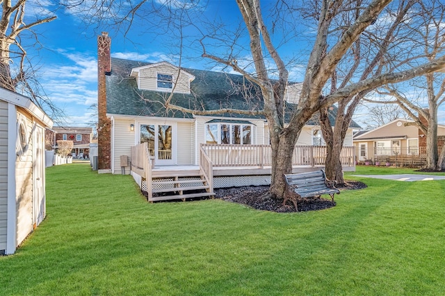 rear view of house with a yard and a wooden deck