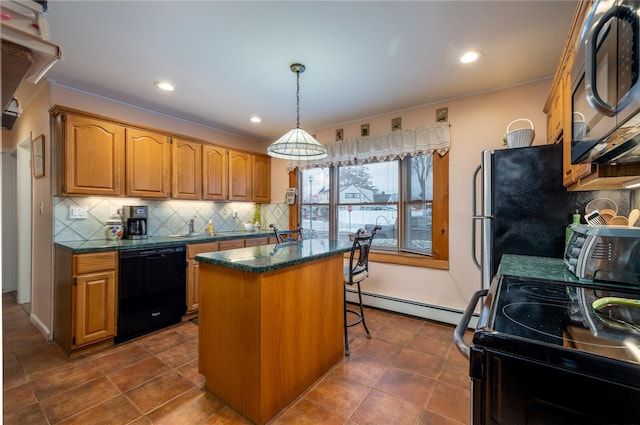 kitchen featuring a center island, hanging light fixtures, a baseboard heating unit, a kitchen bar, and black appliances