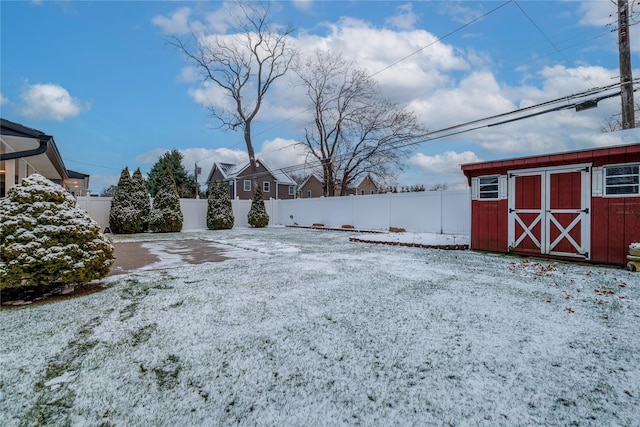 yard layered in snow featuring a storage unit