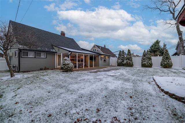 snow covered back of property with covered porch