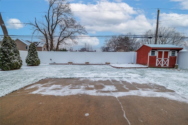 yard layered in snow with a storage unit