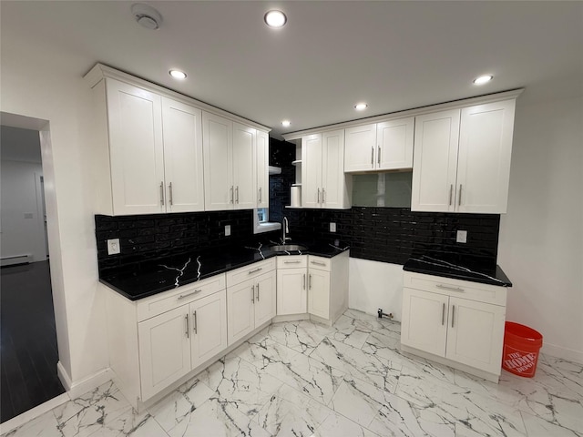 kitchen featuring white cabinets, decorative backsplash, sink, and a baseboard radiator