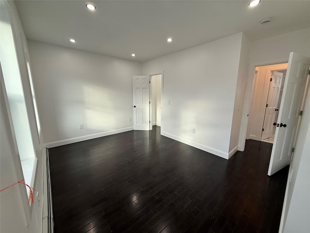 unfurnished room with dark hardwood / wood-style flooring