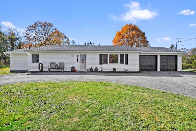 ranch-style house featuring a garage and a front lawn