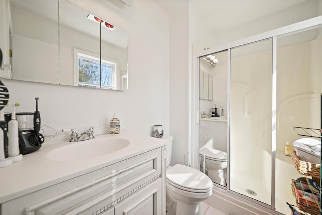 bathroom with vanity, toilet, and a shower with shower door