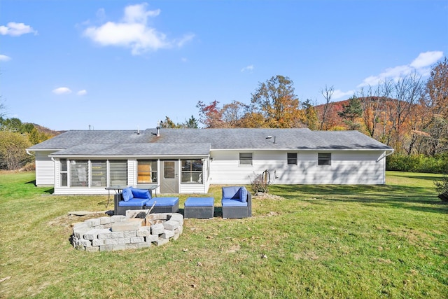 rear view of house with an outdoor living space with a fire pit and a lawn