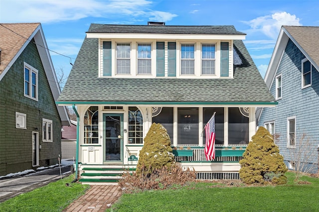 bungalow featuring a shingled roof and a front yard