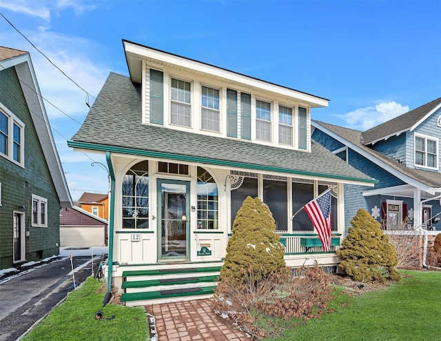 bungalow-style home featuring a shingled roof and a front lawn