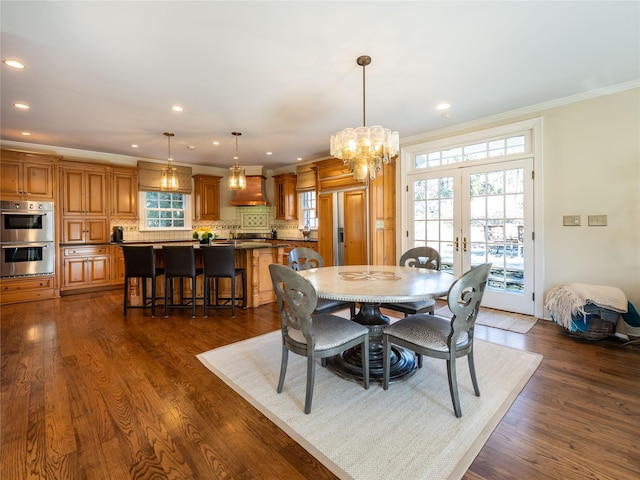 dining space featuring dark hardwood / wood-style floors, crown molding, and french doors