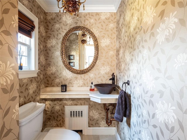 bathroom featuring toilet, crown molding, radiator heating unit, and sink