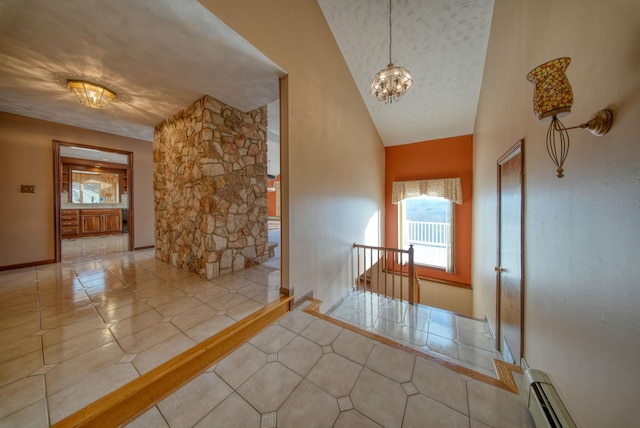 interior space with a baseboard heating unit, light tile patterned flooring, vaulted ceiling, and a chandelier