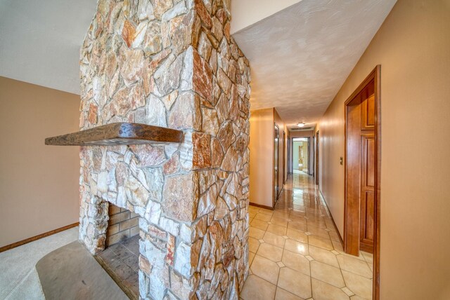 living room with a textured ceiling and a stone fireplace