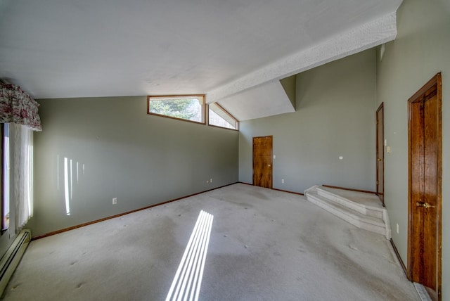 carpeted empty room with a baseboard heating unit and vaulted ceiling with beams