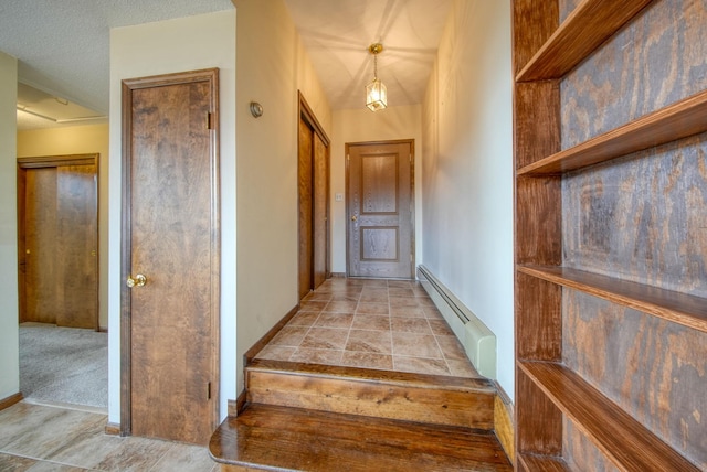 hall with a textured ceiling, a baseboard radiator, and light carpet