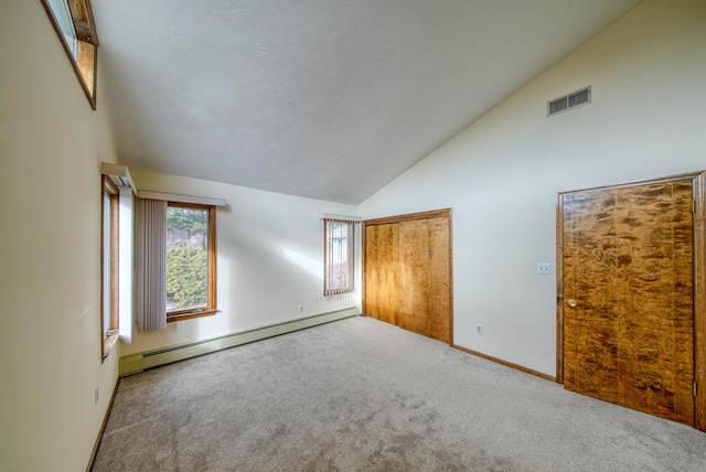 unfurnished bedroom featuring baseboard heating, high vaulted ceiling, carpet floors, and a closet