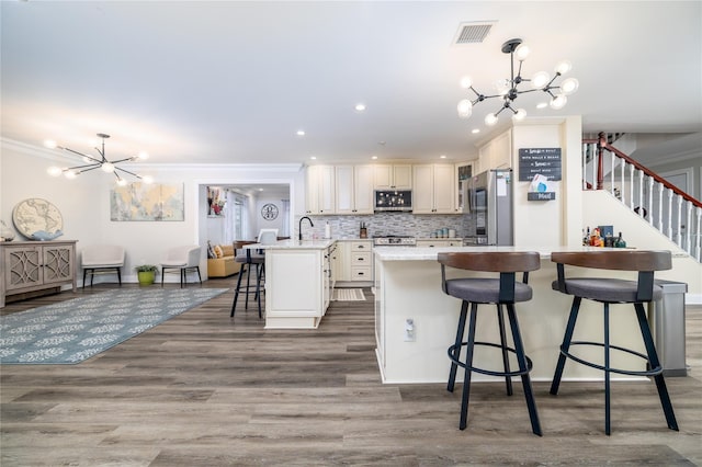 kitchen featuring a breakfast bar, pendant lighting, stainless steel appliances, and a chandelier