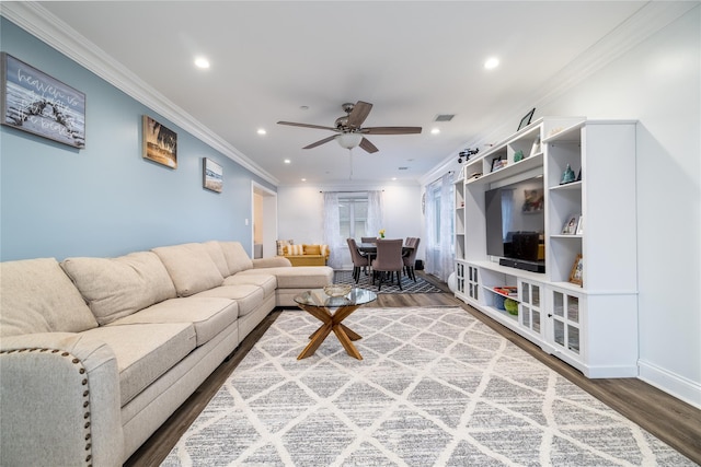 living room featuring ceiling fan, ornamental molding, and wood-type flooring