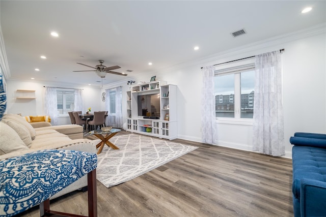 living room with hardwood / wood-style floors, plenty of natural light, ceiling fan, and ornamental molding