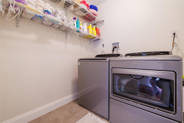 washroom featuring light tile patterned floors and washing machine and clothes dryer