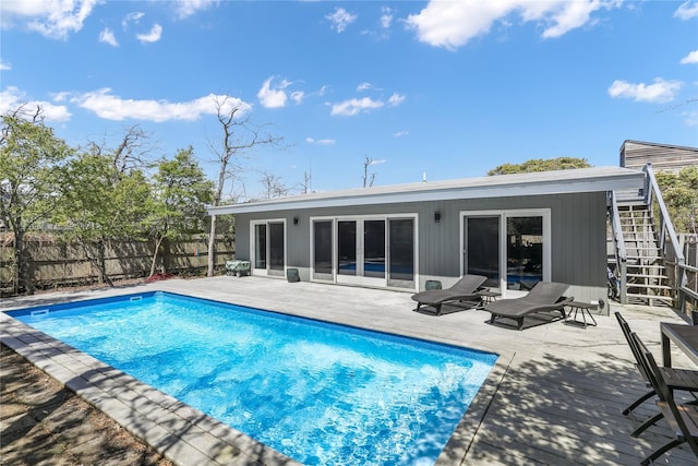 rear view of property featuring a fenced in pool