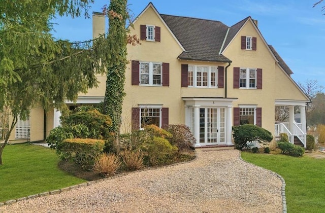 view of front facade with a front yard and french doors