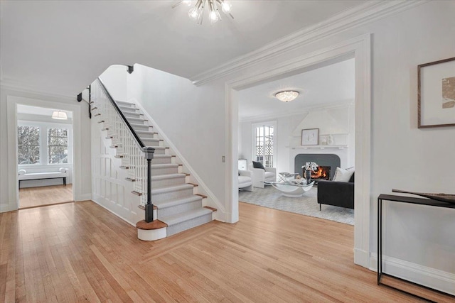 entrance foyer featuring ornamental molding and light hardwood / wood-style flooring