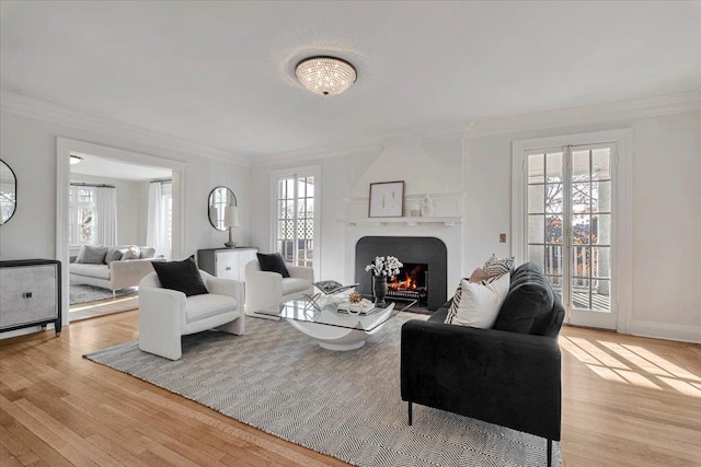 living room with crown molding, plenty of natural light, and light wood-type flooring