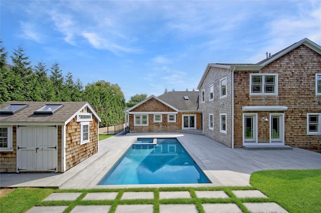 view of swimming pool featuring a patio area and a storage shed