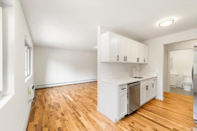 kitchen with a baseboard radiator, light countertops, white cabinetry, a sink, and dishwasher