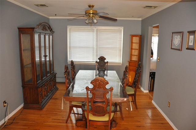 dining space with a baseboard radiator, ceiling fan, ornamental molding, and light hardwood / wood-style floors