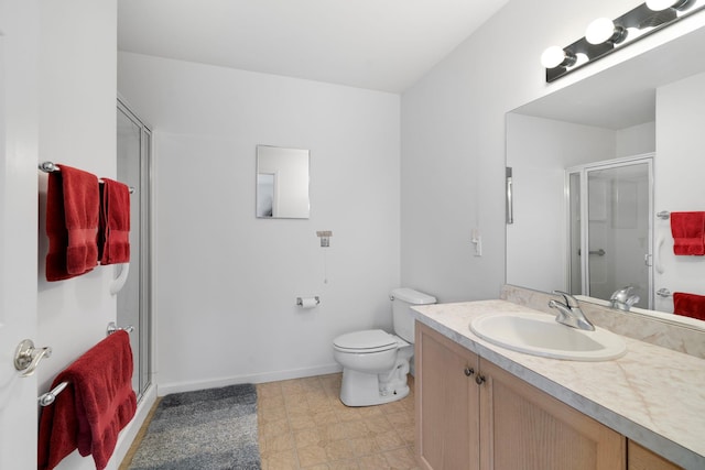 bathroom featuring vanity, a shower with shower door, and toilet