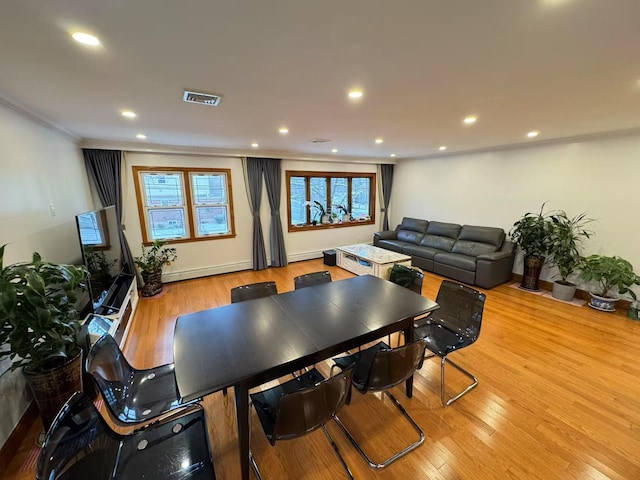 dining space with a baseboard radiator and light hardwood / wood-style flooring