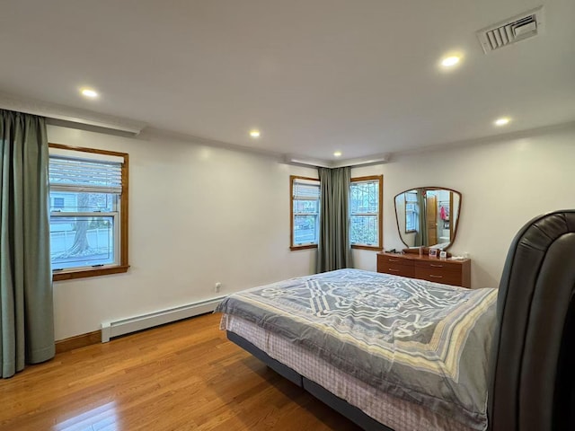 bedroom featuring a baseboard radiator and light hardwood / wood-style flooring