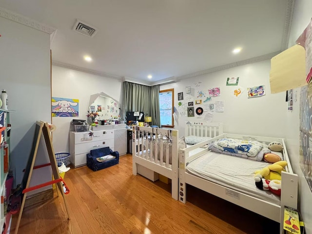 bedroom featuring wood-type flooring and ornamental molding