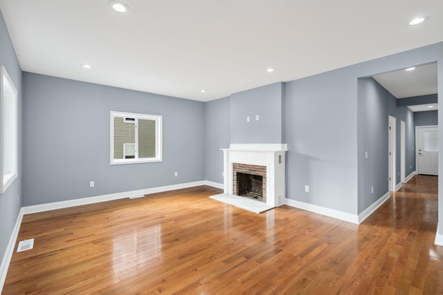 unfurnished living room featuring a fireplace and wood-type flooring