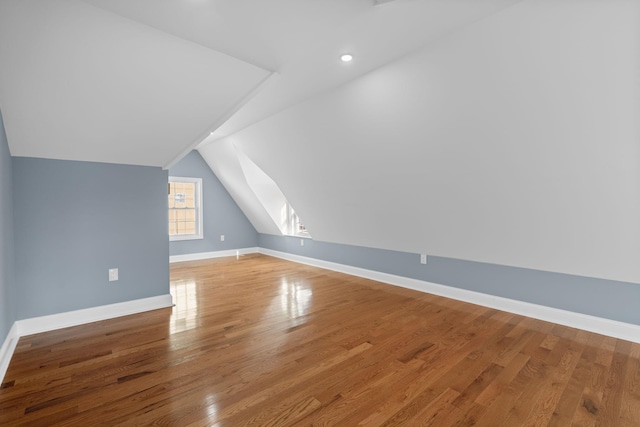 additional living space featuring hardwood / wood-style flooring and vaulted ceiling