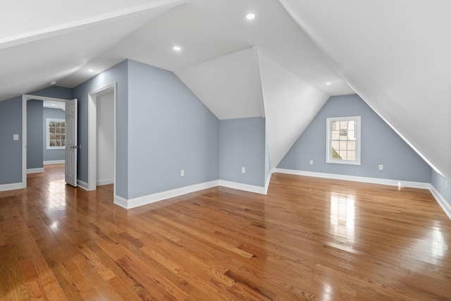 bonus room with light hardwood / wood-style floors and vaulted ceiling