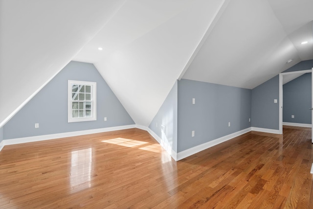 bonus room with hardwood / wood-style floors and vaulted ceiling