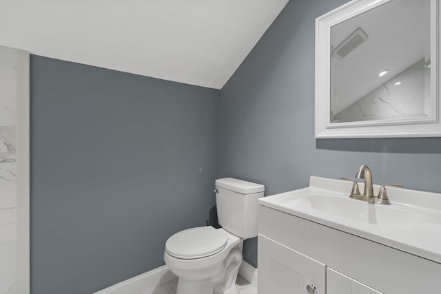 bathroom with vanity, toilet, and vaulted ceiling