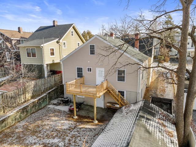 rear view of property featuring a wooden deck and cooling unit