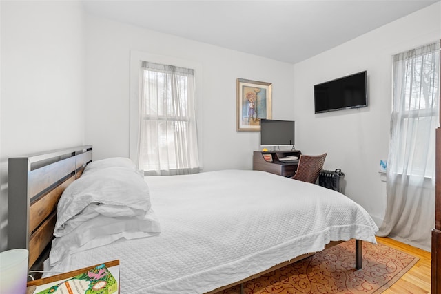 bedroom featuring wood-type flooring and radiator