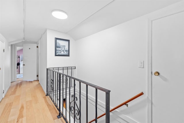 hallway featuring hardwood / wood-style flooring and vaulted ceiling