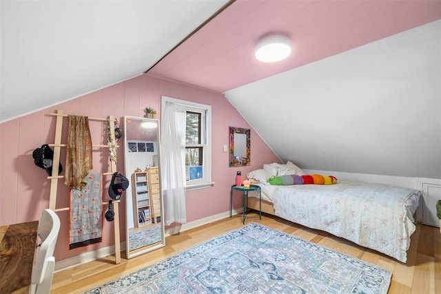 bedroom with vaulted ceiling and hardwood / wood-style flooring