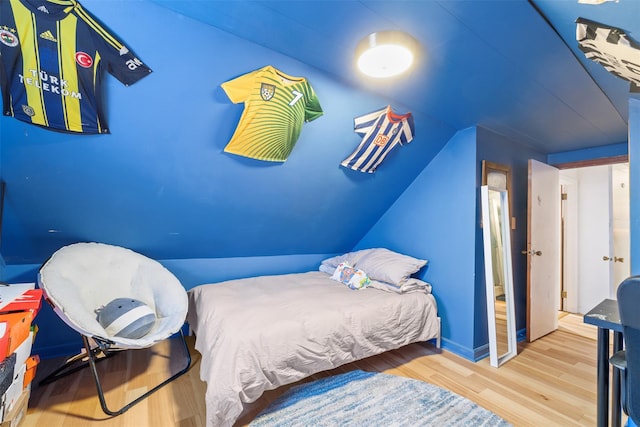 bedroom featuring hardwood / wood-style floors and lofted ceiling