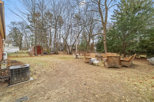 view of yard featuring central AC and a storage unit