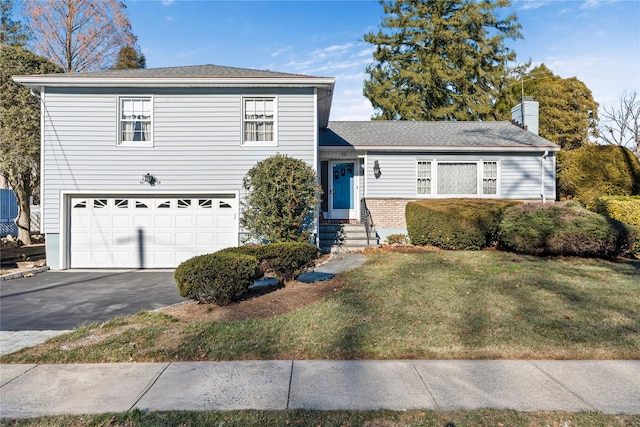 view of front of home with a front yard and a garage